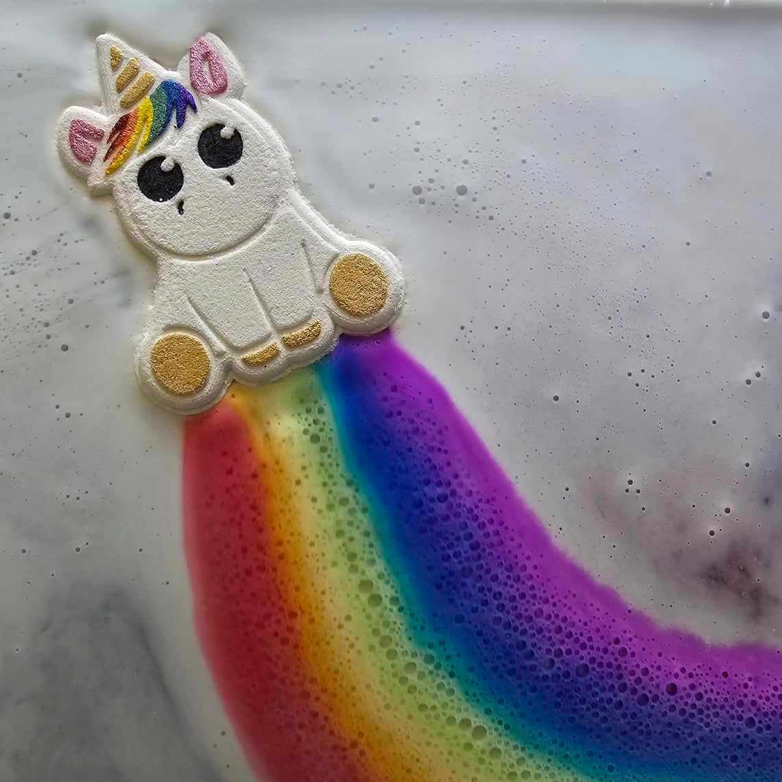 A unicorn bath bomb rainbow in bath water.